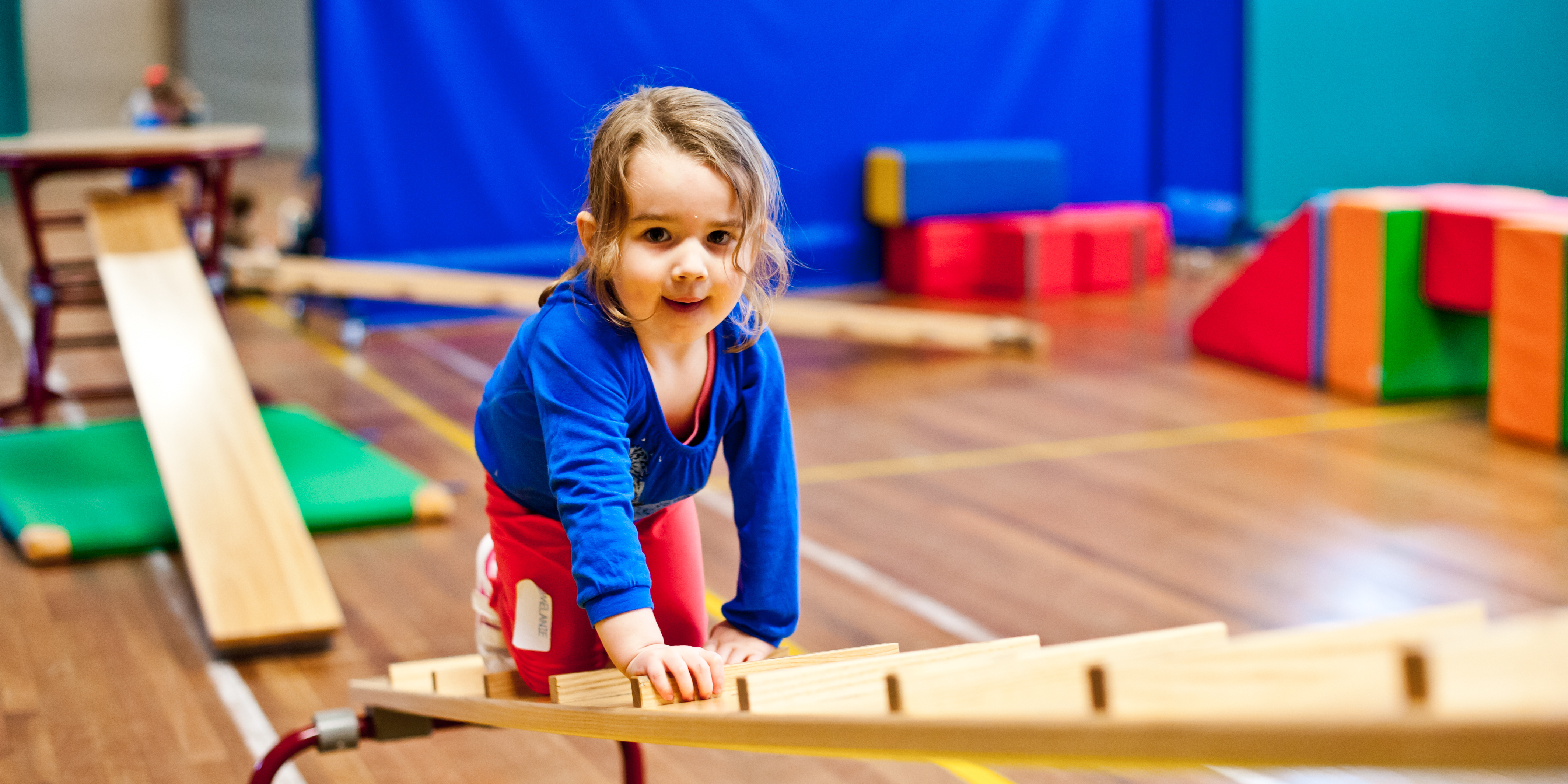Meisje klimt op een schuingeplaatste bank Meisje klimt op een schuingeplaatste bank